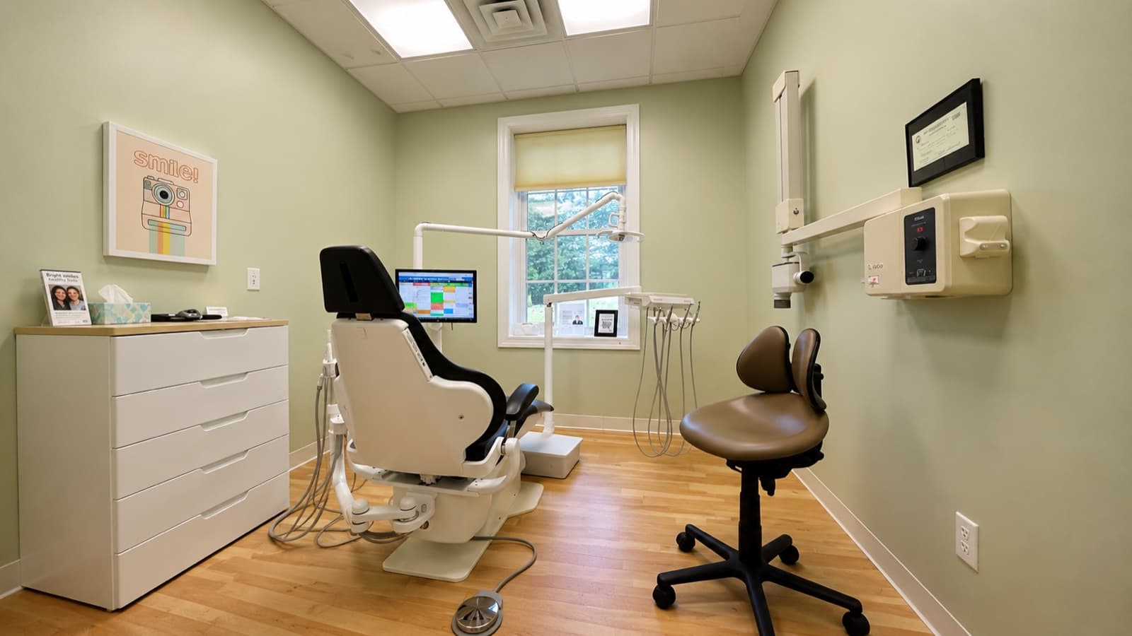 Modern dental treatment room with chair, monitor, and natural light